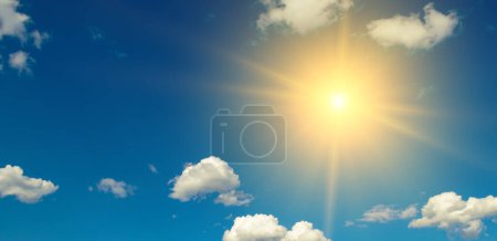 Photo for Bright sun on beautiful blue sky with white fluffy clouds. - Royalty Free Image