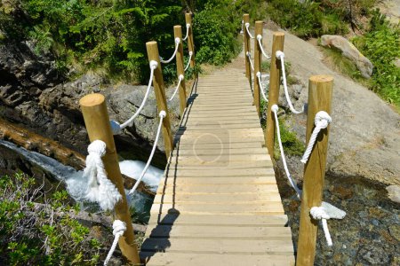 Photo for Pedestrian wooden bridge over mountain river. Europe. - Royalty Free Image