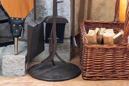 Téléchargez les photos : Vue de certains accessoires de cheminée et d'un panier en bois de chauffage à l'intérieur d'une maison - en image libre de droit