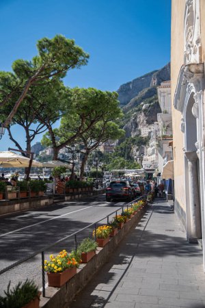 Foto de Bañado por el sol de verano italiano, el terraplén en la ciudad turística de Amalfi, Italia. Vacaciones de verano europeas, camino ancho para caminar. - Imagen libre de derechos