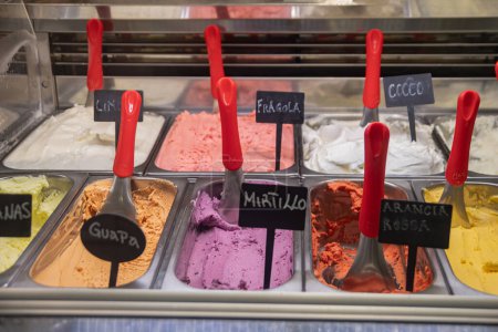 Foto de El escaparate con el helado apetitoso italiano - el helado. Una gran selección de golosinas, un postre tradicional ligero - Imagen libre de derechos