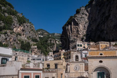 Photo for Sunny summer day on the Amalfi Coast, Italy. Umberto I Square. Beautiful Italian architecture, stone houses in the mountains. House with a clock - Royalty Free Image