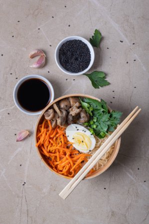 Photo for Noodle soup, ramen in a white bowl (bowl) with chicken egg, carrots, mushrooms on a light stone background. Asian traditional fast food - Royalty Free Image