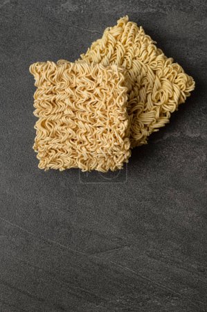 Photo for Square dry egg noodles in a briquette on a gray stone marble (slate) background. Asian fast food. - Royalty Free Image