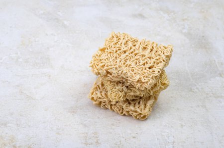 Photo for Square dry egg noodles in a briquette on a light beige stone marble background. Asian fast food. - Royalty Free Image