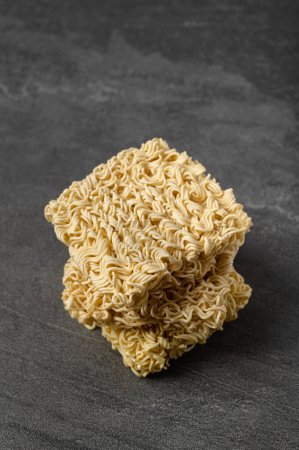 Photo for Square dry egg noodles in a briquette on a gray stone marble (slate) background. Asian fast food. - Royalty Free Image
