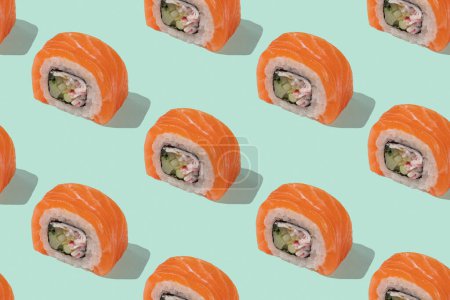 Japońskie sushi z łososiem, smocze bułki na pastelowym zielonym tle. Sztuka pop, tło, wzór. Tradycyjna żywność azjatycka