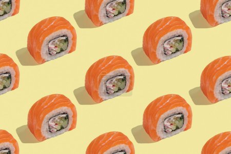 Japońskie sushi z łososiem, smocze bułki na pastelowym żółtym tle. Sztuka pop, tło, wzór. Tradycyjna żywność azjatycka