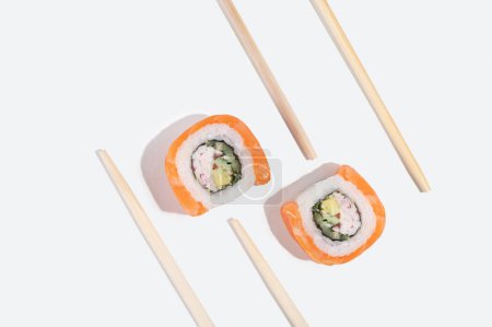 Trzy japońskie sushi z łososiem, smocze bułki na pastelowym żółtym tle. Sztuka pop. Smaczne przekąski. Tradycyjna żywność azjatycka