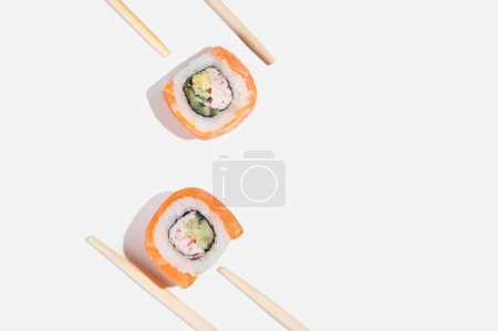 Téléchargez les photos : Trois sushis japonais au saumon, des rouleaux de dragon sur un fond jaune pastel. Pop art. Délicieuses collations. Alimentation traditionnelle asiatique - en image libre de droit