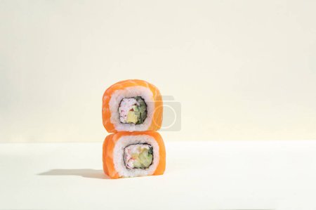 Para japońskiego sushi łososiowego, smocze bułki na jasnożółtym tle. Sztuka pop. Smaczne przekąski pałeczki. Tradycyjna żywność azjatycka