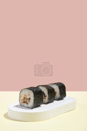 Photo for Asian culture, Japanese hosomaki (sushi, rolls) with eel on a pink and yellow background. Oriental culinary, eastern cooking. Tasty appetizers on platter - Royalty Free Image