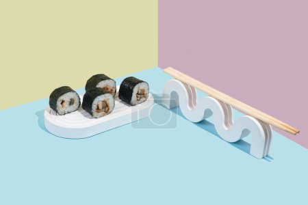 Téléchargez les photos : Hosomaki (sushis, rouleaux) avec anguille sur un support en plâtre blanc sur un fond uni coloré (bleu, rose, jaune). Une composition simple et concise - en image libre de droit