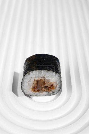 Foto de Hosomaki (sushi, rollos) con anguila en un soporte de yeso blanco. Una composición simple y concisa - Imagen libre de derechos