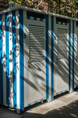 Téléchargez les photos : Vestiaires à rayures bleues et blanches et toilettes sur la plage à Positano Italie - en image libre de droit