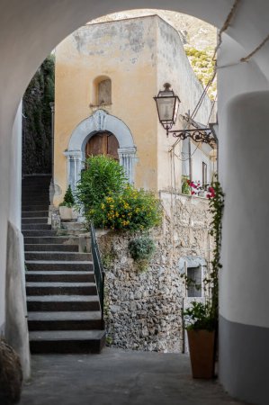 Téléchargez les photos : Jolies rues anciennes, pierreuses et étroites avec des maisons anciennes dans le village de Positano dans le sud de l'Italie. Promenades dans les anciens lieux historiques d'Europe - en image libre de droit