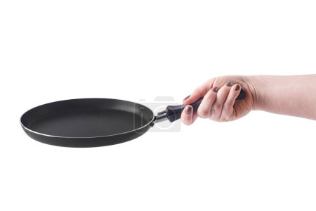 Flat pancake pan on a white background. A woman's light-skinned hand is holding a frying pan