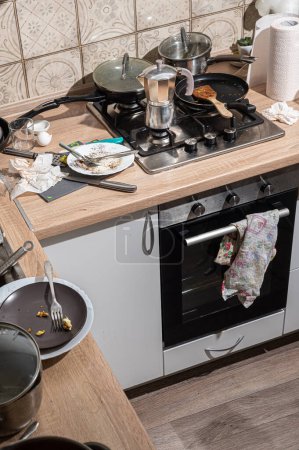 Foto de Cocina desordenada con platos sucios apilados en el fregadero y en el mostrador. Cocina moderna con fachadas blancas al estilo escandinavo - Imagen libre de derechos