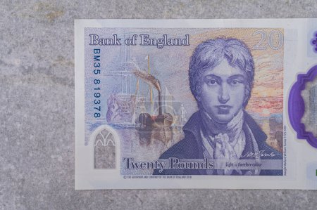Foto de Moneda de Gran Bretaña (Inglaterra) libra. Billetes con denominación y 20 retratos de Joseph Mallord William Turner sobre fondo gris - Imagen libre de derechos