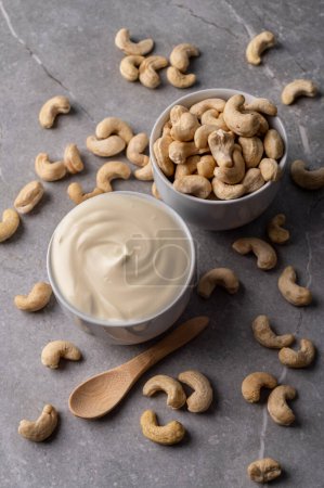 Photo for Cashew nut cream cheese in a white bowl, plate on a gray marble stone background. This image represents a healthy snack option and can be used to convey concepts like nutrition, veganism, natural food, and wellness. - Royalty Free Image