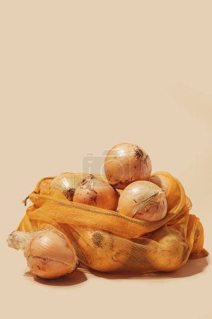 Photo for Reusable tote bag filled with fresh onions, showcasing eco-friendly usage and sustainable shopping practices. This image promotes conscious consumerism and the importance of reducing plastic waste. - Royalty Free Image