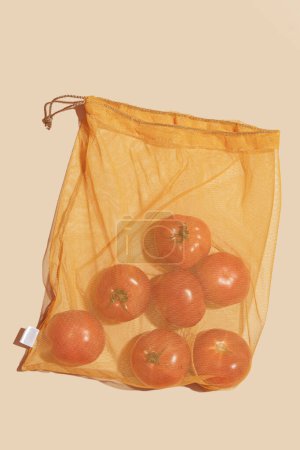 Foto de Bolsas reutilizables para comprar verduras y frutas. Bolsas con tomates. Cuidado ecológico, consumo consciente, cuidado de la naturaleza. Día Mundial del Reabastecimiento - Imagen libre de derechos