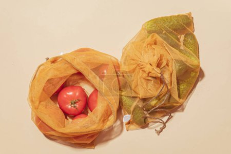 Foto de Bolsas reutilizables para comprar verduras y frutas. Bolsas con tomates y pepinos. Cuidado ecológico, consumo consciente, cuidado de la naturaleza. Día Mundial del Reabastecimiento - Imagen libre de derechos