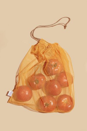 Téléchargez les photos : Sacs réutilisables pour acheter des légumes et des fruits. Sacs aux tomates. Eco soin, consommation consciente, soin de la nature. Journée mondiale du ravitaillement - en image libre de droit