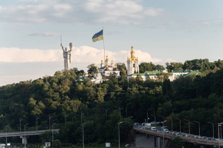 Foto de 10 de julio de 2023 - Kiev, Ucrania. Vista de las laderas del Dniéper - la estatua de la Patria y el Kiev-Pechersk Lavra desde el puente peatonal (parque) - Imagen libre de derechos