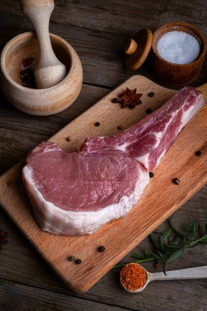Photo for Indulge in the rustic charm of a raw piece of pork loin on a wooden board. This mouthwatering dish combines savory flavors with a rustic presentation, creating a culinary masterpiece - Royalty Free Image