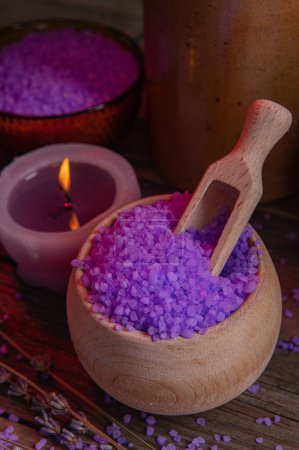 Photo for Lavender salt and scented candle for the bathroom, for spa and relaxation in a rural cottage interior. Wooden warm texture, coziness. Aromatherapy, relaxation - Royalty Free Image