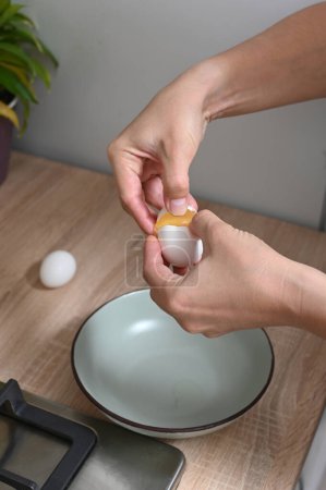 Téléchargez les photos : Woman breaks eggs to make an omelette. Female hands hold a chicken egg. Home cooking, hearty home-made simple dishe - en image libre de droit