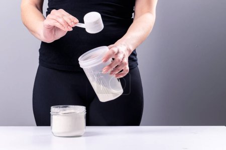 Photo for Woman makes a collagen mixture in a mixing glass. Sports nutrition: drink with protein - Royalty Free Image