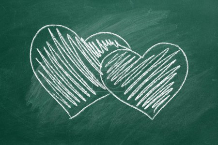 Foto de Dos corazones son dibujados a mano con tiza en un invernadero. Día de San Valentín. Concepto de amor. Te amo. - Imagen libre de derechos