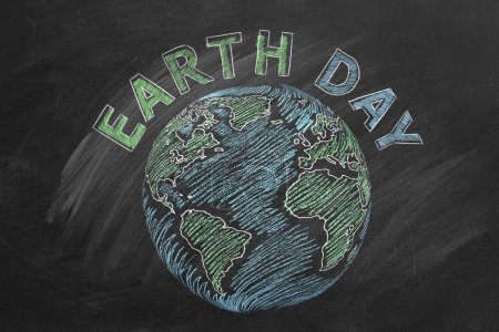 Photo for The world with lettering EARTH DAY hand drawn in chalk on a school blackboard. - Royalty Free Image