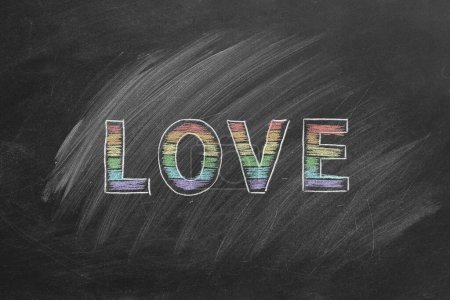 Téléchargez les photos : Le mot amour est écrit à la craie sur un tableau noir. Concept LGBT, droits LGBTQIA et égalité des sexes. Mois de la fierté. Déclaration d'amour, acceptation des sentiments, donner de l'amour. - en image libre de droit