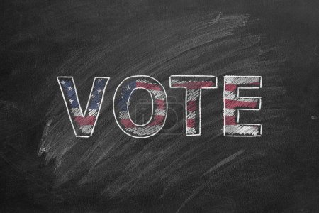 Handwritten word VOTE in blackboard. Vote in American election. American Presidential Election