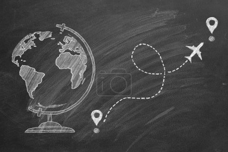 Foto de Tiempo para viajar. Una ilustración dibujada con tiza de un globo terráqueo en una pizarra, y un avión siguiendo un camino marcado con alfileres de localización que sugieren un concepto de viaje o educación. - Imagen libre de derechos