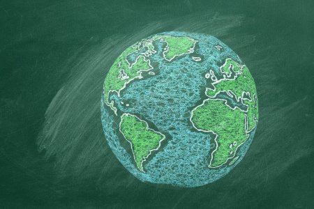 Foto de Un dibujo tiza de la Tierra en una pizarra de aula verde, mostrando continentes en colores vibrantes y rodeados de océanos - Imagen libre de derechos
