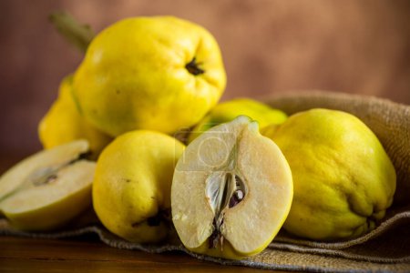 Photo for Ripe natural autumn quince on a dark wooden table. - Royalty Free Image