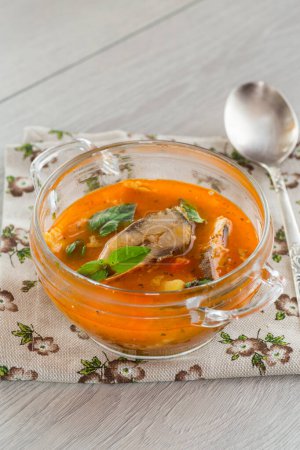 Téléchargez les photos : Soupe de tomates de légumes avec du poisson dans une assiette sur une table en bois - en image libre de droit