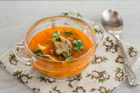 Téléchargez les photos : Soupe de tomates de légumes avec du poisson dans une assiette sur une table en bois - en image libre de droit