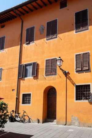 Téléchargez les photos : Maison brillamment peinte en orange. Superbe fond coloré. Pise, Italie - en image libre de droit