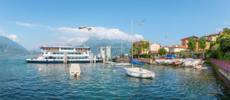 Téléchargez les photos : Vue panoramique de la marina avec un ferry à Varenna sur le lac de Côme - en image libre de droit