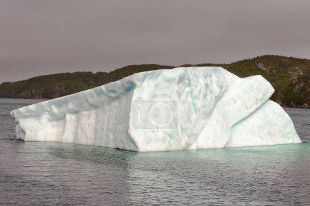 Photo for Massive iceberg melts away in coastal waters of Atlantic Ocean off Newfoundland, NL, Canada - Royalty Free Image