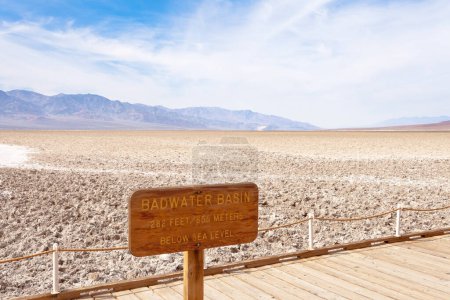 Téléchargez les photos : Promenade publique avec panneau indicateur dans le bassin Badwater point le plus bas sous le niveau de la mer du paysage désertique désolé de la vallée de la mort, parc national de la vallée de la mort, Californie, Californie, États-Unis - en image libre de droit
