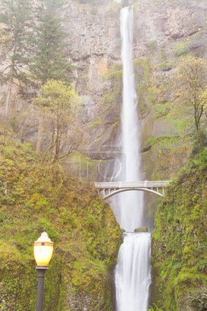 Photo for Benson Footbridge over silky water of famous landmark Multnomah Falls with lantern of viewing area, Columbia River valley near Portland, Oregon, OR, USA - Royalty Free Image