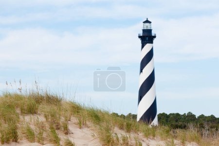 Photo for Cape Hatteras Lighthouse towers over beach dunes of Outer Banks island near Buxton, North Carolina, US - Royalty Free Image