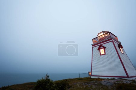Foto de Trinity Harbour Lighthouse on Fort Admirals Point in niebla crepúsculo, Península de Bonavista, Terranova, NL, Canadá - Imagen libre de derechos