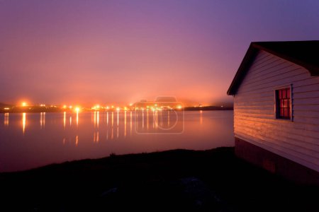 Foto de Luces de la aldea histórica de Trinity en el crepúsculo brumoso de Fort Point a través de Trinity Harbour, Terranova, NL, Canadá - Imagen libre de derechos